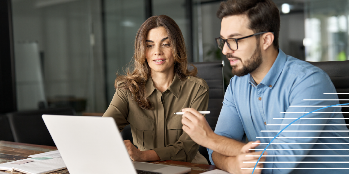 Two colleagues reviewing information together on a laptop in an office.